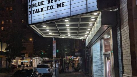 Cinema marquee illuminated at night on a street