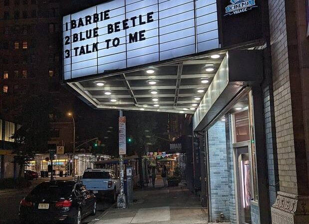 Cinema marquee illuminated at night on a street