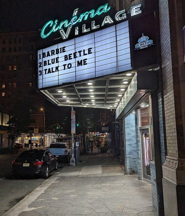 Cinema marquee illuminated at night on a street