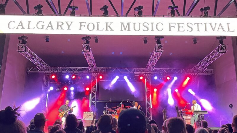 Festival audience facing a brightly lit main stage