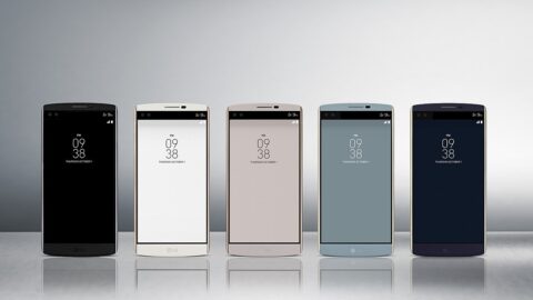 Row of smartphones in different colours on a reflective surface