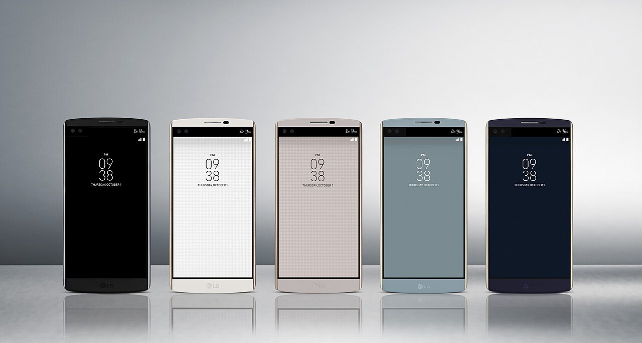 Row of smartphones in different colours on a reflective surface