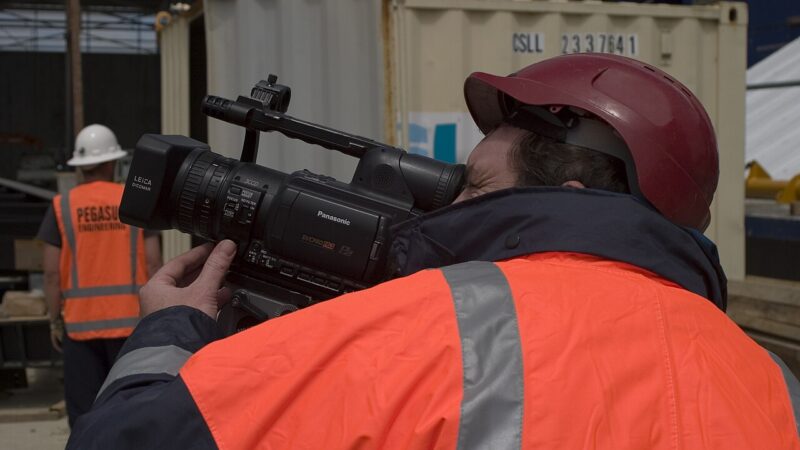 Camera operator filming with a professional video camera