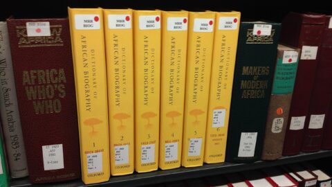 Reference books on shelves in a library reading room