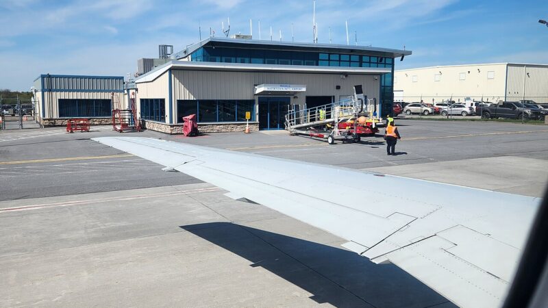 Aircraft wing and airport apron before takeoff