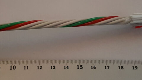 Color-coded fiber optic cable strands next to a ruler
