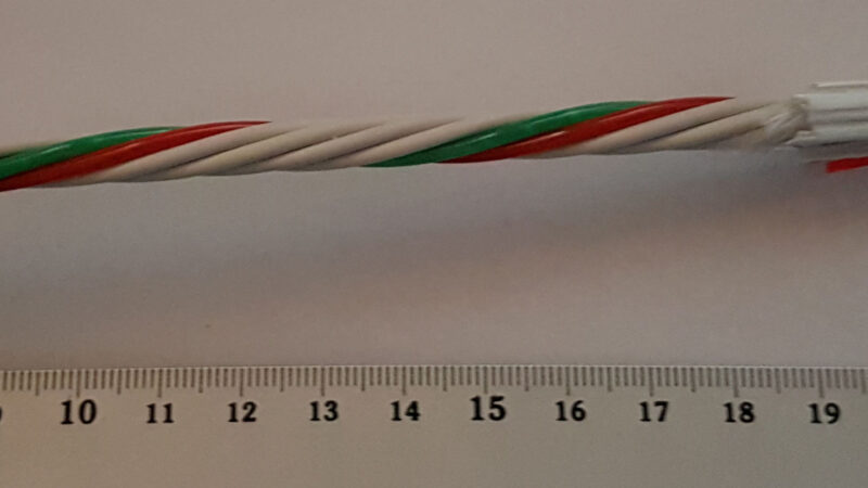 Color-coded fiber optic cable strands next to a ruler